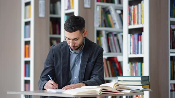 Student Studying in Library and Smiling at Camera