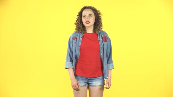 Curly Female Feels Very Bad, Her Stomach Hurts on Yellow Background at Studio