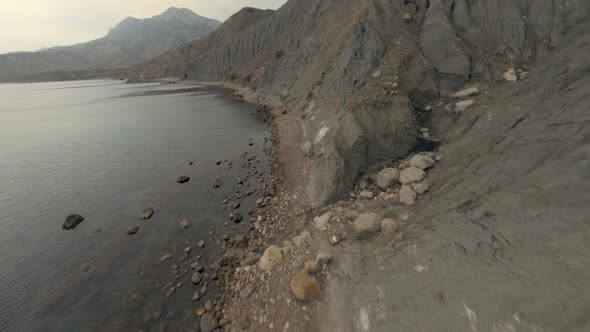 Aerial Shot Flying Natural High Cliff Mountain Surrounded By Sea Coast with Fog Fpv Sports Drone