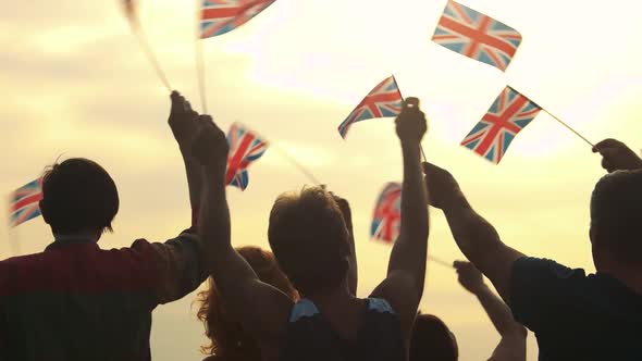 Patriotic UK Crowd Waving with Flags Outdoors