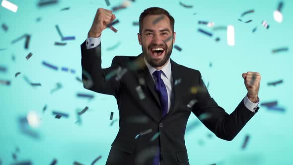 Excited businessman champion guy celebrating winning under confetti rain