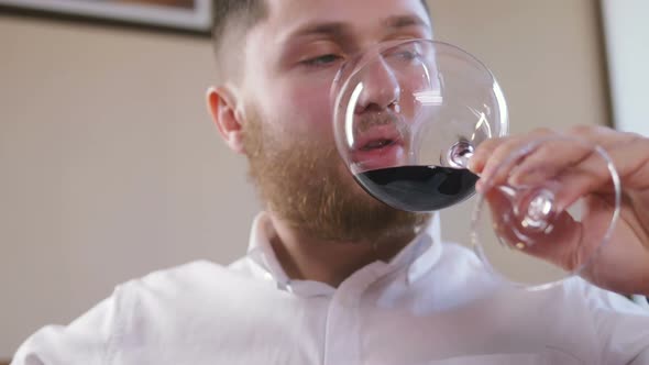 Young Man Drinking Wine From a Glass in Restaurant