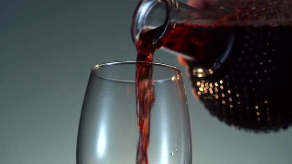 Pouring Rose Wine From a Transparent Bottle on the White Background in