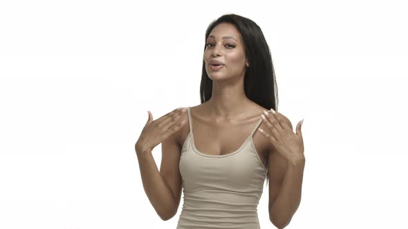 Beautiful Africanamerican Woman in Beige Tanktop Feeling Hot and Excited Waving at Herself to Cool