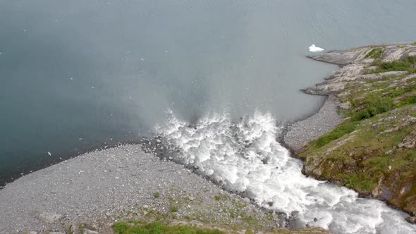 White Powerful Flowing Of Cascade Through Lichen Mountains Surrounded By Flying Sea Birds In Alaska,