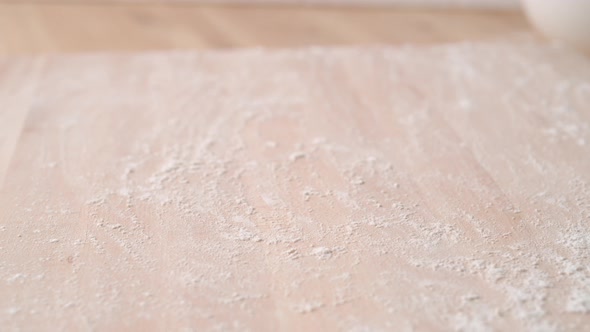 Camera follows a dough falling on a table. Slow Motion.