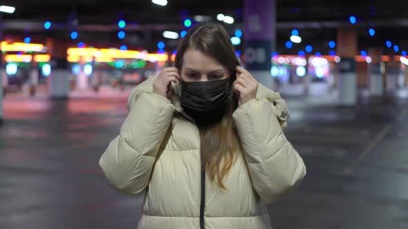 Young Woman in a Protective Black Mask on Her Face