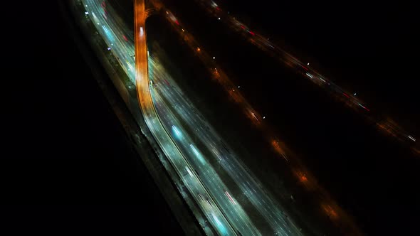 Night Timelapse Aerial View of Busy Traffic Road with City Skyline