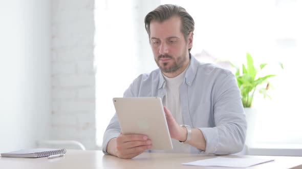 Young Man Using Tablet While Sitting in Office