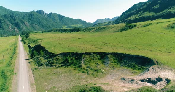 Aerial Rural Mountain Road and Meadow at Sunny Summer Morning. Asphalt Highway and River.