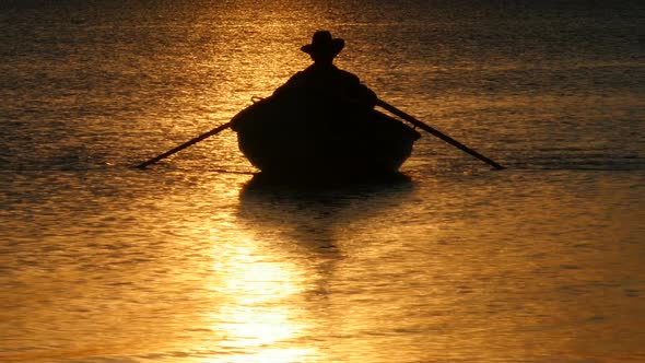Silhouette of Angler Fishing From Rowing Boat at Sunset