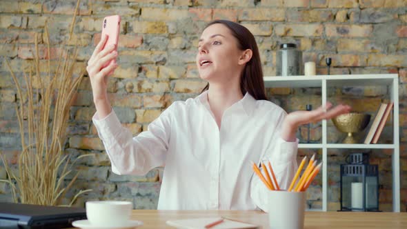 Young Businesswoman Having a Video Call in Office with Smartphone