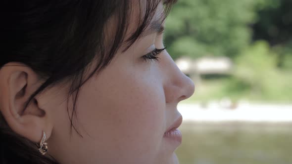 Side View Of Face Of Young Attractive Caucasian Woman Examines With Interest