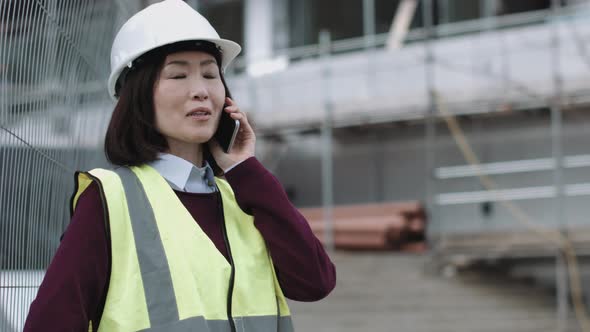 Construction supervisor speaking on phone at construction site