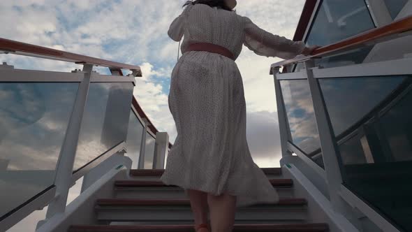 Young girl in a dress climbing the stairs