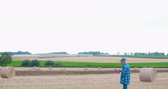 Farmer with Tablet Computer Analyzing Crops at Farm