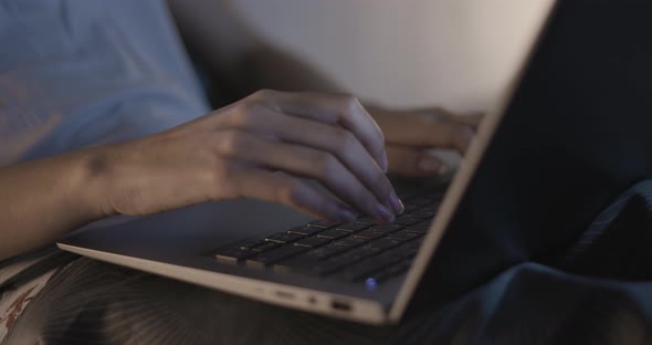 Woman working with her laptop in the bedroom