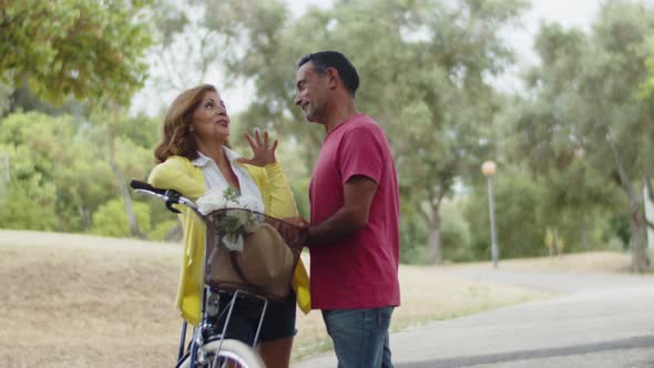 Caucasian Lovers Standing Next to Bike Looking at Each Other