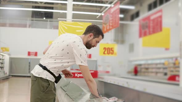 A Man Chooses Frozen Meat