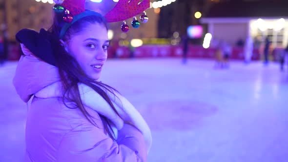 People Enjoy Ice Skating in the Street Around Christmas Tree in Rink