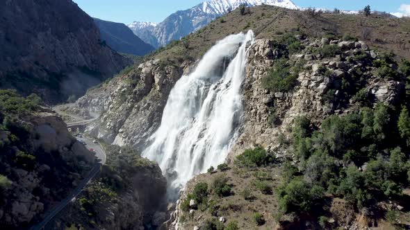 Aerial: big waterfall on the mountains next to the road
