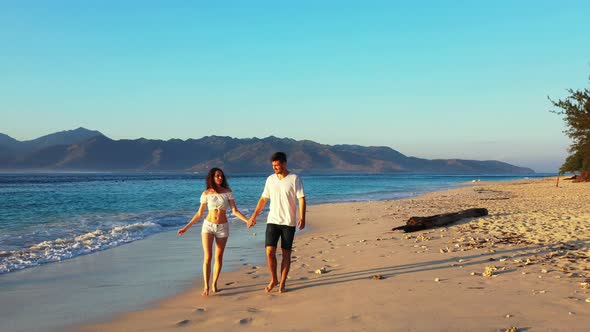 Beautiful couple on honeymoon vacation spend quality time on beach on white sand background 4K