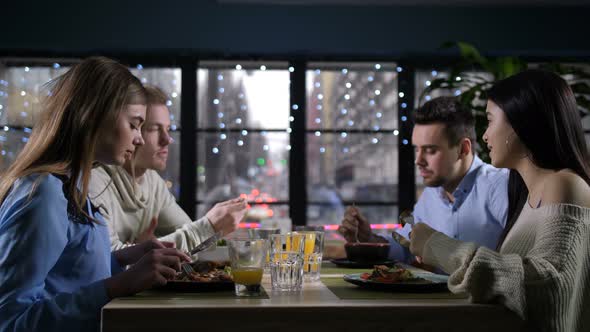 Young Mates Suppering, Conversating in Restaurant