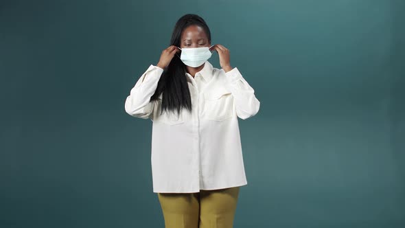 An Attractive Cheerful African Lady is Putting on Medical Mask for Health Protection and Prevention