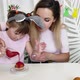 Mom and Daughters Pour Red Icing on Easter Cupcake - VideoHive Item for Sale