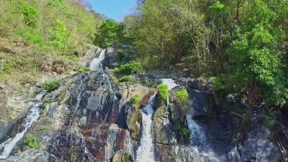 Drone Shows Waterfall Follows River Cascade Against Blue Sky