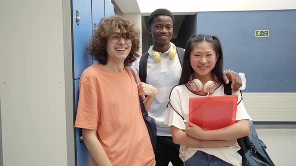 Portrait of Three Multiracial Students Looking at the Camera Smiling at a High School