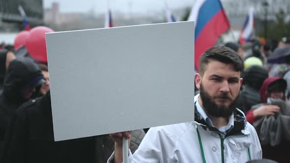 Bearded Man on Rally Holding Blank Ads Board