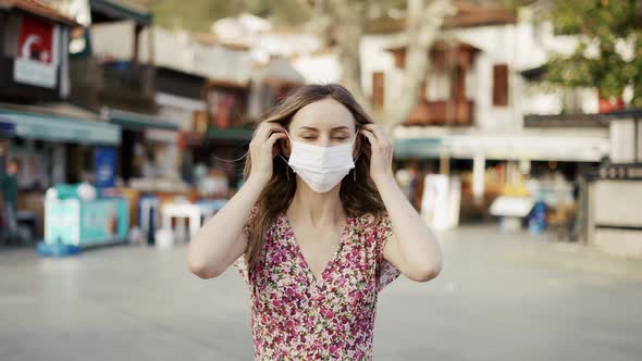 Blonde Woman Putting on Medical Mask for Coronavirus Protection