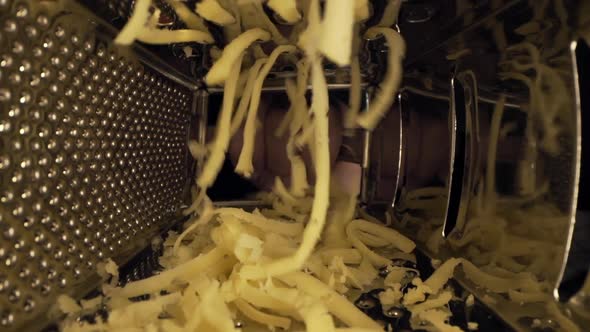 Macro Video of Grating Cheese, View Inside the Grater, Close Up Food, Cooking with Grated Cheese