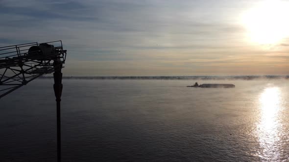 Aerial view from the drone, the boat sails on the river in the morning, the fog and the sun complete