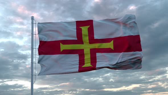 Realistic Flag of Guernsey Waving in the Wind Against Deep Dramatic Sky