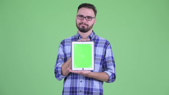 Stressed Young Bearded Hipster Man Showing Digital Tablet