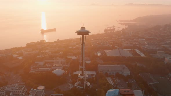 Establishing wide aerial of the Space Needle during sunset with a layer of smoky haze over the Puget