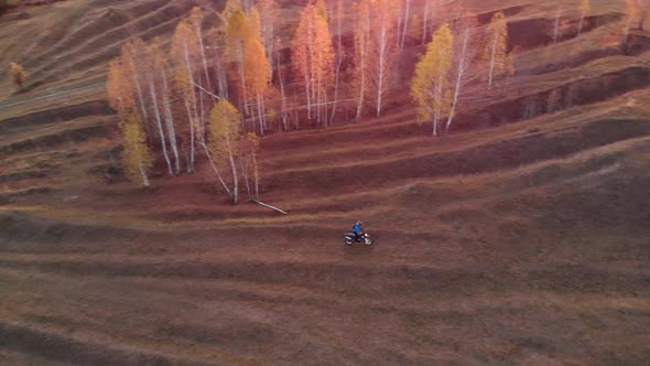 Man on motorcycle rides through the hills