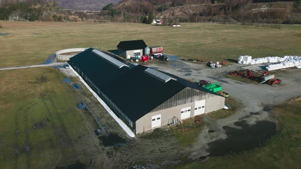 Dairy Barn, Silo, And Enclosure For Milk Production On Agricultural Landscape In Norway. aerial orbi