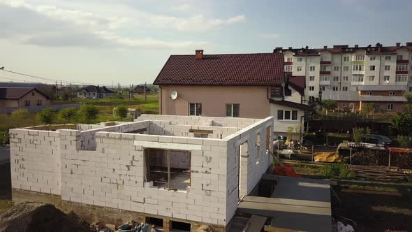Aerial view of unfinished house walls under construction at building site.