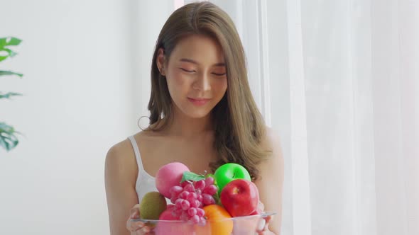 Slow motion of Healthy Asian woman holding fresh healthy fruits and happiness