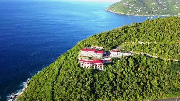 Aerial fly in close up of cliffside home on the British Virgin Island of Tortola.