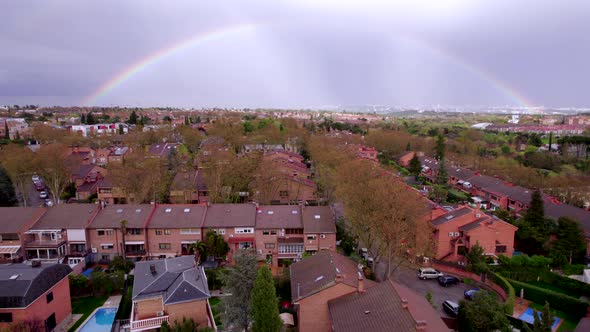 Aerial view Full rainbow in the sky over residential neighborhood. Madrid, Spain