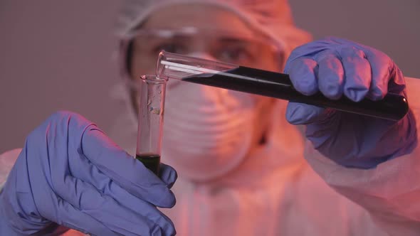 Protected Scientist Pouring Liquid in a Laboratory. Research and Science Concept