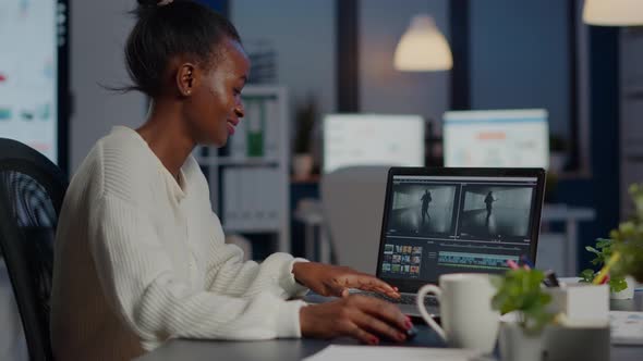 Black Delighted Videographer Editing Movie on Professional Laptop