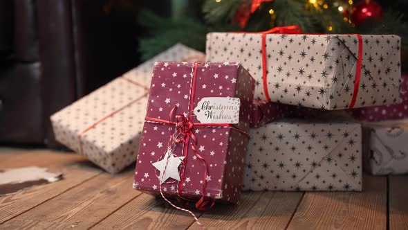 Christmas Beautiful Gift Boxes in a Stack of Presents Lie on the Wooden Floor Under the Tree