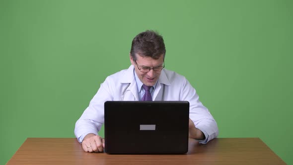 Mature Handsome Man Doctor Against Green Background