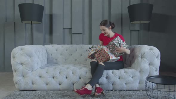 Excited Woman Unpacking Birthday Gifts at Home