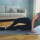 Woman with Long Ponytail Does Supine Side Leg Raises in Room - VideoHive Item for Sale